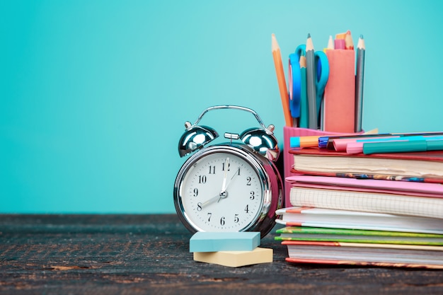 Concepto de regreso a la escuela. Libros, lápices de colores y reloj.