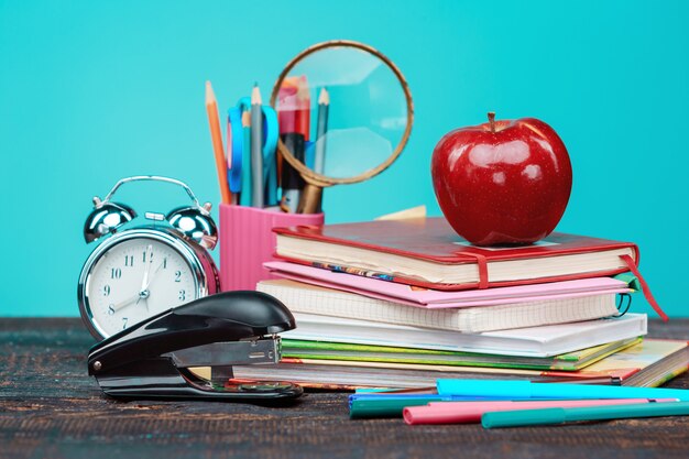 Concepto de regreso a la escuela. Libros, lápices de colores y reloj.