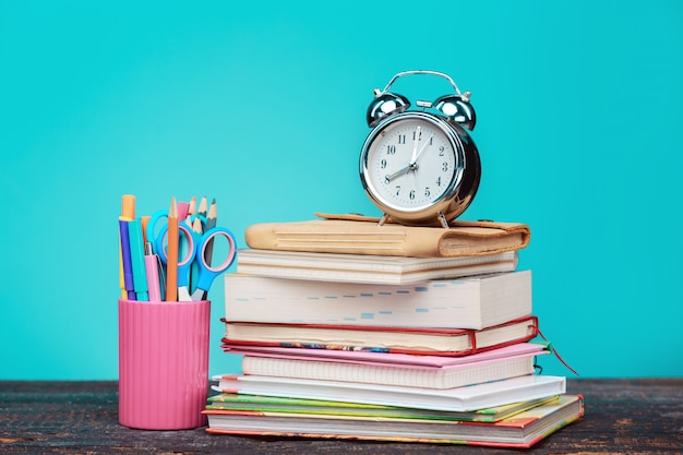 Concepto de regreso a la escuela. Libros, lápices de colores y reloj.
