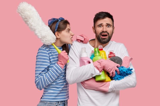 Foto gratuita concepto de relaciones y trabajo doméstico. irritada mujer joven disgustada grita enojada al marido perezoso