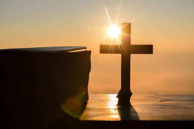 Concepto de la resurrección de Jesucristo: silueta cruzada en el fondo del amanecer de la colina