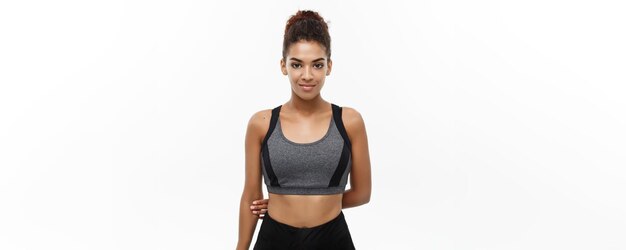 Concepto de salud y fitness Hermosa dama africana americana en ropa de fitness lista para hacer ejercicio Aislada sobre fondo blanco