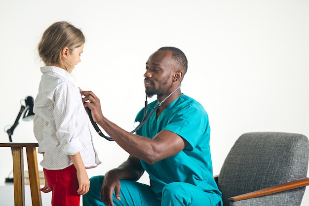 Concepto de salud y médico - médico con estetoscopio escuchando cofre infantil en el hospital
