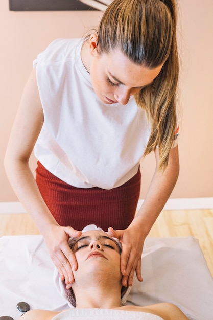 Foto gratuita concepto de spa con crema facial y mujer relajada