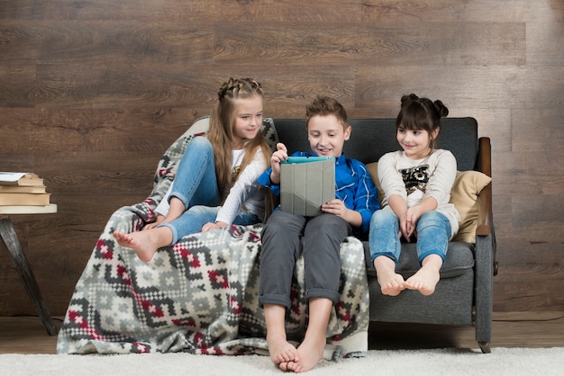 Concepto de tecnología con niños en sofá