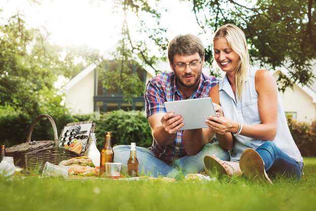 Concepto de tecnología de tableta digital de relajación de unión de picnic de personas