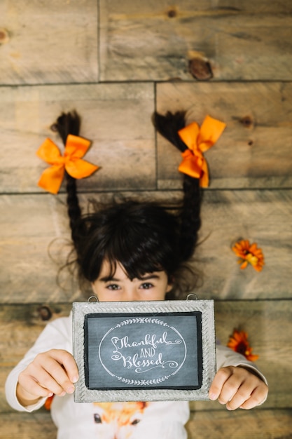 Foto gratuita concepto de thanksgiving con niña enseñando pizarra