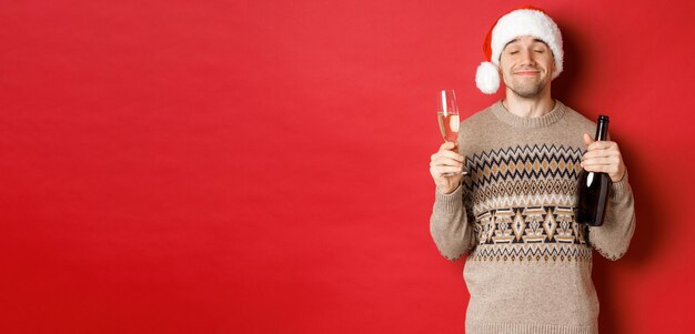 Concepto de vacaciones de invierno Navidad y celebración imagen de hombre sonriente complacido en sombrero de santa y s ...