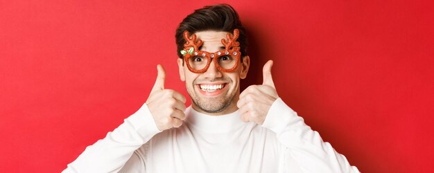 Concepto de vacaciones de invierno navidad celebración primer plano de excitado hombre guapo en copa de fiesta...