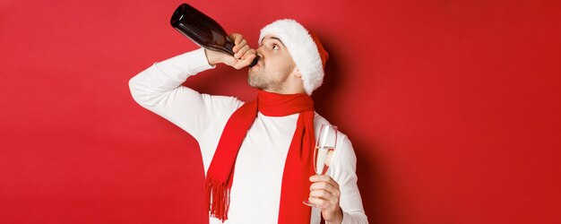 Concepto de vacaciones de invierno navidad y estilo de vida hombre emborrachándose en la fiesta de año nuevo bebiendo cham