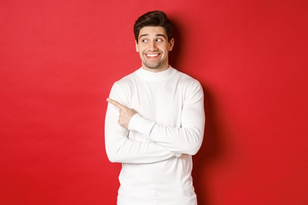 Concepto de vacaciones de invierno navidad y estilo de vida hombre guapo emocionado en suéter blanco sonriendo loo ...