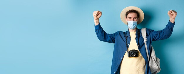 Foto gratuita concepto de vacaciones de verano y covid turista sonriente feliz celebrando vacaciones con mascarilla gritando