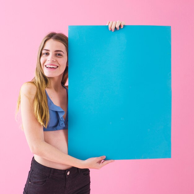 Concepto de verano con chica sujetando cartel azul