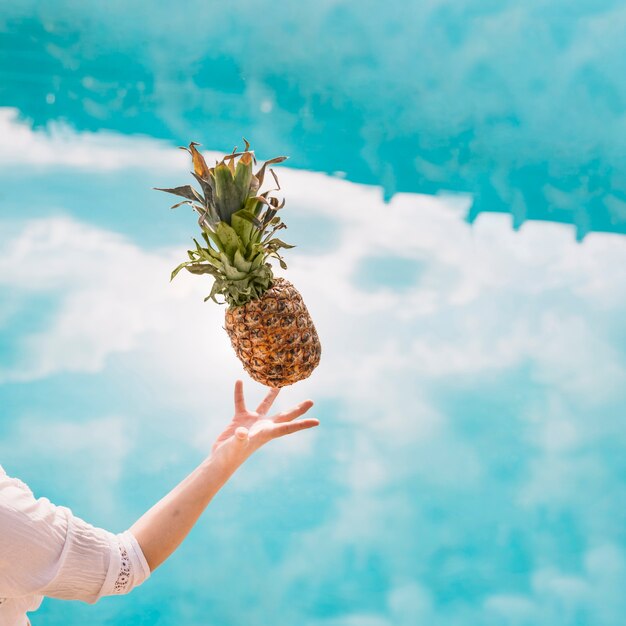 Concepto de verano y piscina con brazo y piña