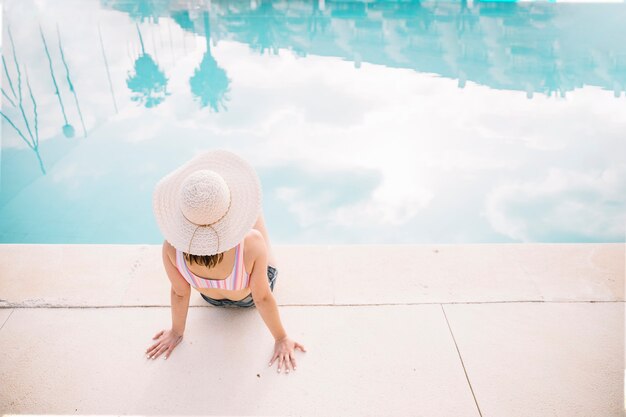 Concepto de verano y piscina con mujer sentada