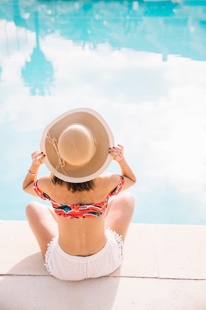 Concepto de verano y piscina con vista trasera de mujer