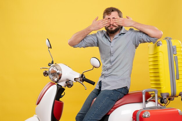 Concepto de viaje con joven barbudo sentado en motocicleta y cerrando los ojos en amarillo