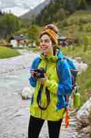 Foto gratuita concepto de viajes y actividades al aire libre. caminante femenino encantador optimista camina por el pequeño arroyo de montaña