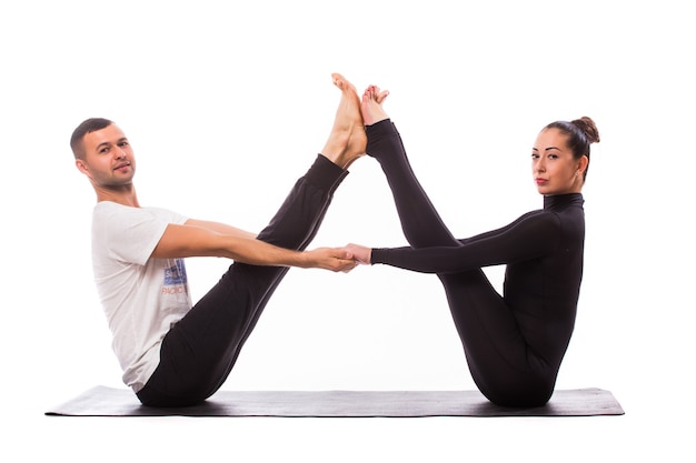 Concepto de yoga en pareja. Pareja joven sana en posición de yoga sobre fondo blanco.