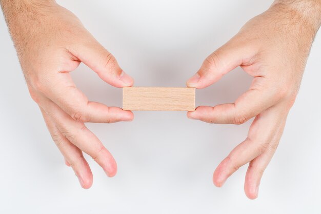 Conceptual del hombre elegido con etiqueta de madera con ambas manos. en la vista superior de fondo blanco. imagen horizontal