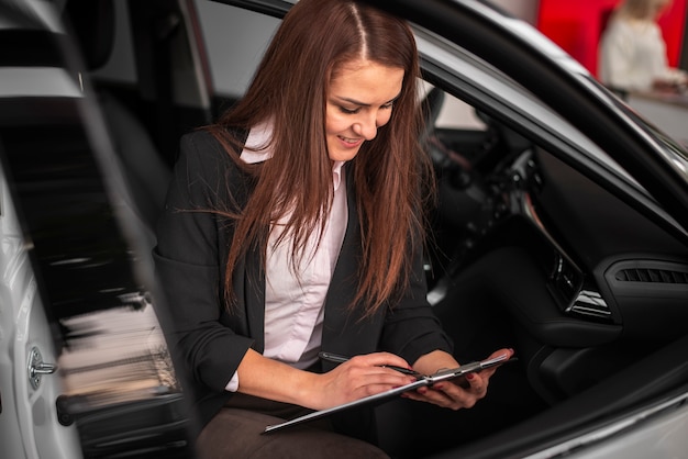 Foto gratuita concesionario de automóviles jóvenes firmando papeles