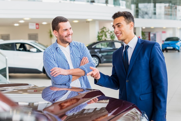 Foto gratuita concesionario de coches hablando a cliente