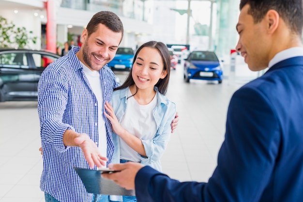 Foto gratuita concesionario de coches hablando a clientes