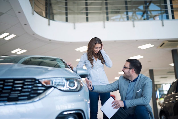 Concesionario de coches presentando coche nuevo al cliente