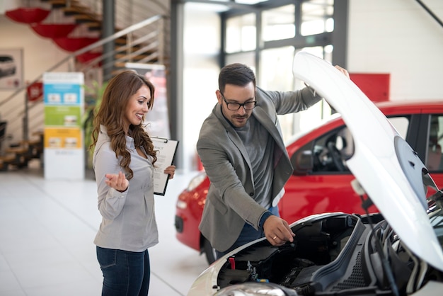 Concesionario de coches que presenta el vehículo al comprador.