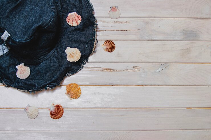 Foto gratuito conchas marinas y sombrero sobre superficie de madera blanca