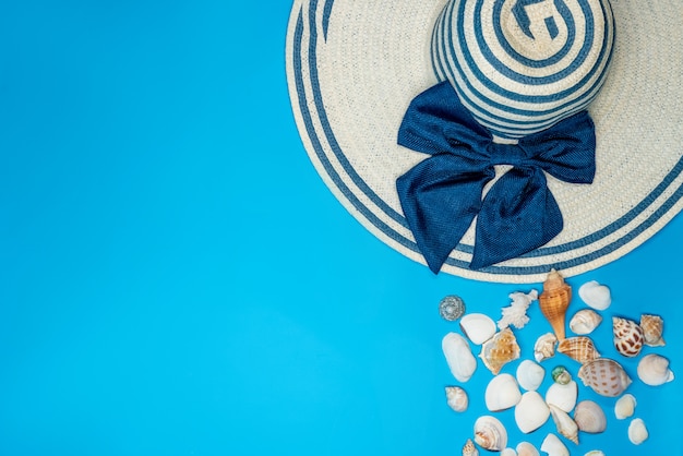 Foto gratuita conchas y sombrero de verano con rayas azules y lazo.