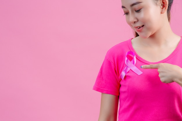 Foto gratuita concientización sobre el cáncer de mama, mujer en camiseta rosa con cinta de raso rosa en el pecho, símbolo de concienciación sobre el cáncer de mama