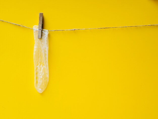 Condón amarillo colgando en el tendedero