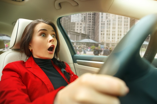 Foto gratuita conducir por la ciudad. atractiva mujer joven conduciendo un coche