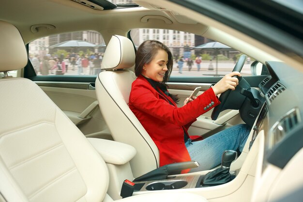 Conducir por la ciudad. Mujer atractiva joven conduciendo un coche.