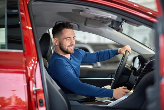 Foto gratuita conductor moreno probando auto nuevo y cambiando de velocidad