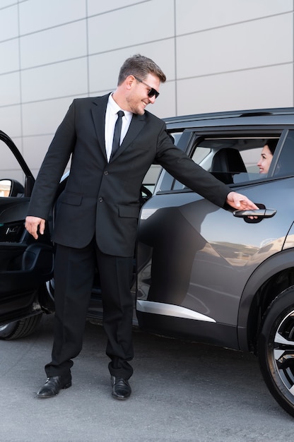 Foto gratuita conductor con puerta de coche abierta