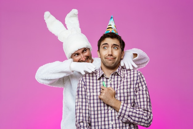 Conejo aterrador hombre borracho sobre pared púrpura. Fiesta de cumpleaños.