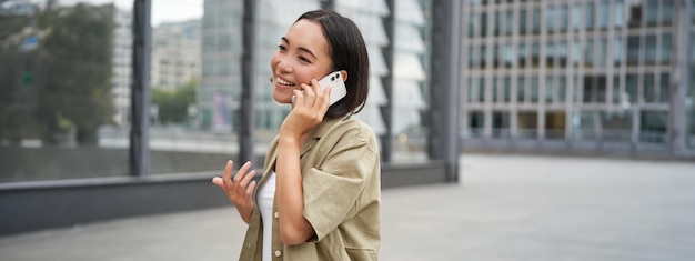 Foto gratuita conexión celular joven asiática hace una llamada telefónica hablando por teléfono inteligente móvil y