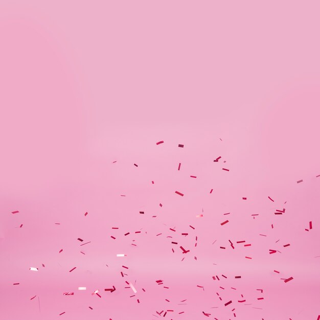 Confeti oscuro sobre fondo rosa