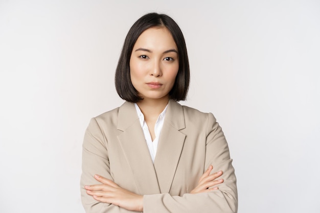Confiada empresaria mujer de negocios asiática de pie en pose de poder persona de negocios profesional cruzar los brazos sobre el pecho de pie sobre fondo blanco