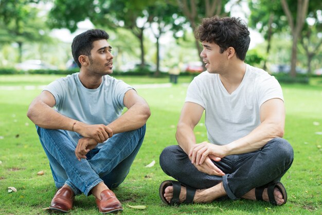 Confiados jóvenes amigos discutiendo las últimas noticias.