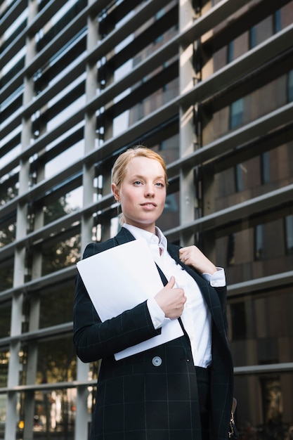 Foto gratuita confianza empresaria joven de pie fuera de la oficina