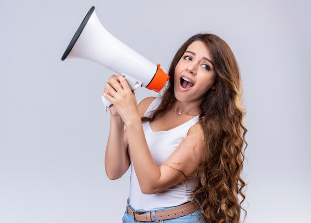 Confianza hermosa joven hablando por altavoz mirando al lado derecho