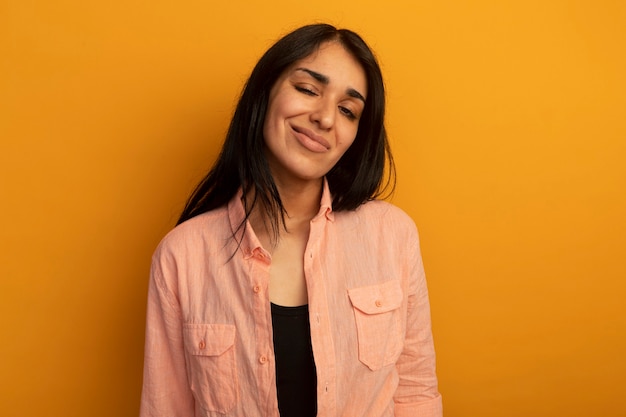 Foto gratuita confianza hermosa joven vestida con camiseta rosa aislada en la pared amarilla con espacio de copia