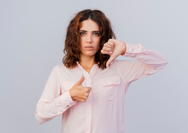 Foto gratuita confianza joven mujer caucásica pulgares arriba y pulgares abajo