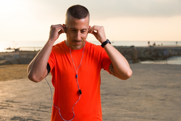 Confidente, macho, atleta, poniendo, auriculares