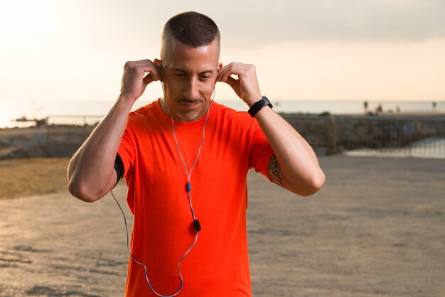 Confidente, macho, atleta, poniendo, auriculares