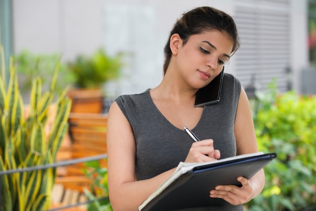 Foto gratuita confidente mujer secretaria hablando por teléfono móvil