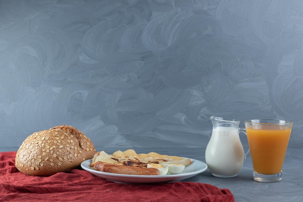 Configuración de desayuno sobre un mantel rojo sobre mesa de mármol.